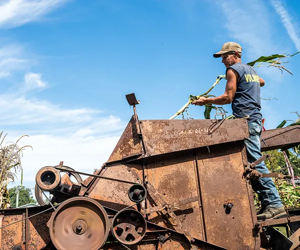 Man operating vintage farm equipment