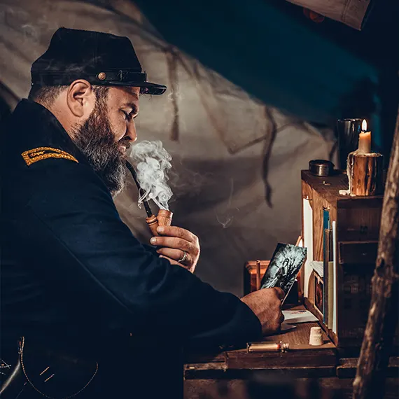 Man in Civil War military uniform smoking a pipe