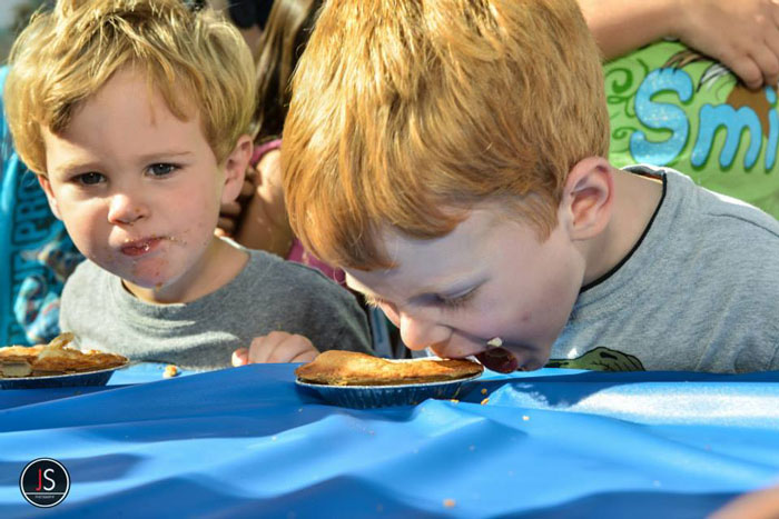 Two children participate in a pie-eating contest.